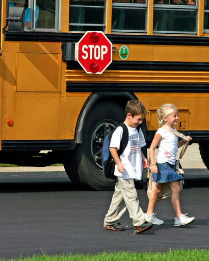 Photo of young children and a school bus