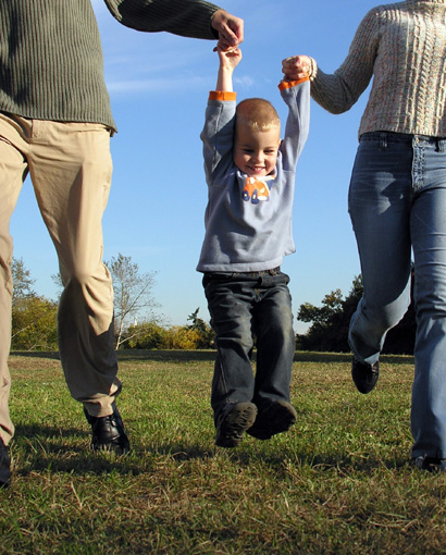 Photo of a young family walking and smiling